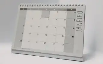 Agenda aberta sobre uma mesa com anotações financeiras e calculadora