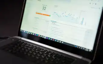 Dashboard de analytics com usuários ativos e páginas mais vistas em um notebook