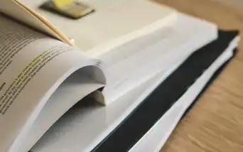 Livro sobre gestão de negócios aberto em uma mesa de trabalho