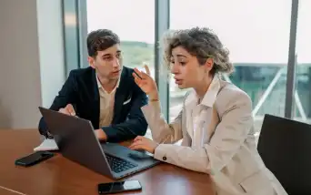 Dois profissionais em conversa séria em uma sala de reunião